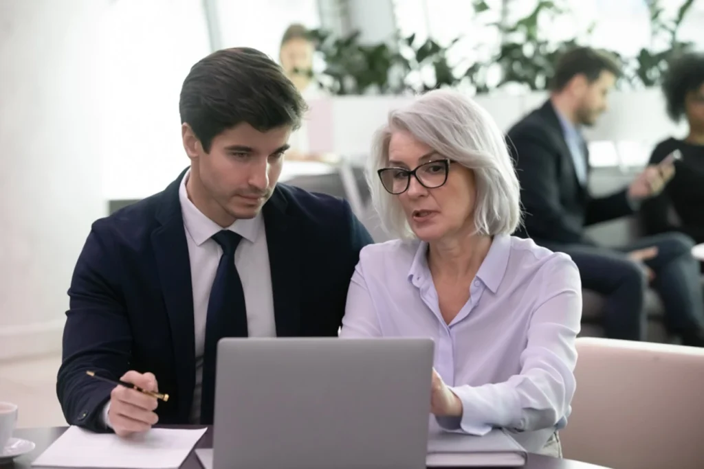 Profissionais de diferentes gerações colaborando em um ambiente corporativo moderno.