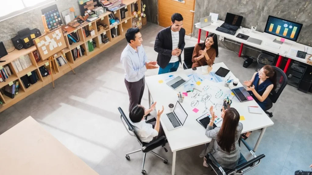 Equipe diversa de profissionais de diferentes gerações colaborando em um ambiente moderno de trabalho.