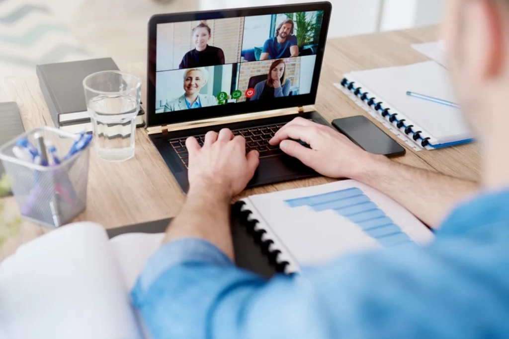 Profissional em home office participando de uma videoconferência com colegas de equipe, demonstrando colaboração e trabalho remoto eficiente.