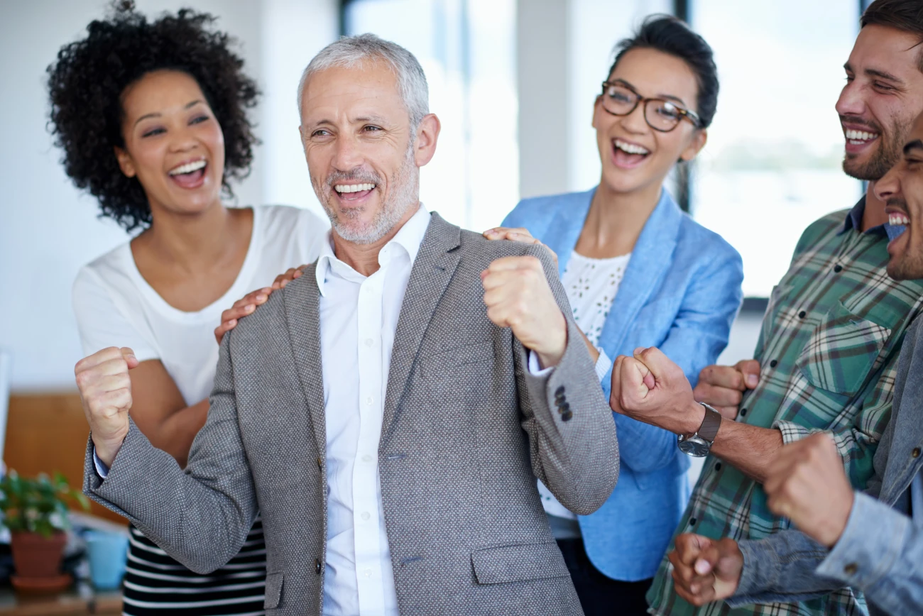 Equipe celebrando resultados após treinamento corporativo bem-sucedido.