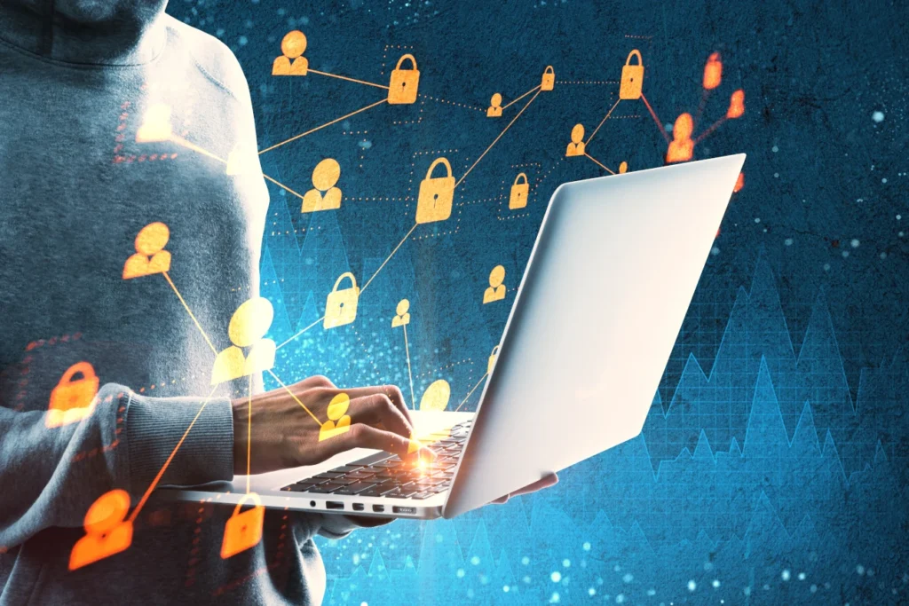 Pessoa usando laptop com ícones digitais de cadeados e conexões, representando segurança da informação e proteção de dados.