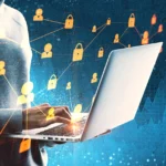 Pessoa usando laptop com ícones digitais de cadeados e conexões, representando segurança da informação e proteção de dados.