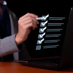 Lista de verificação digital com itens marcados por check exibida sobre um laptop, representando avaliações ou treinamentos padronizados em formato de checklist.