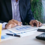 Persona analizando datos de costos en una tablet digital, representando la elección de un LMS accesible.