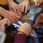 Grupo de personas resolviendo un rompecabezas juntas, que representa la colaboración necesaria para cerrar brechas de habilidades