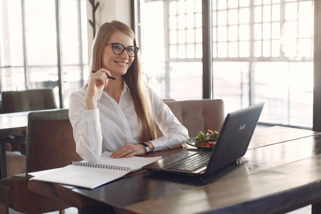 Mulher usando laptop com café — LMS fácil de usar