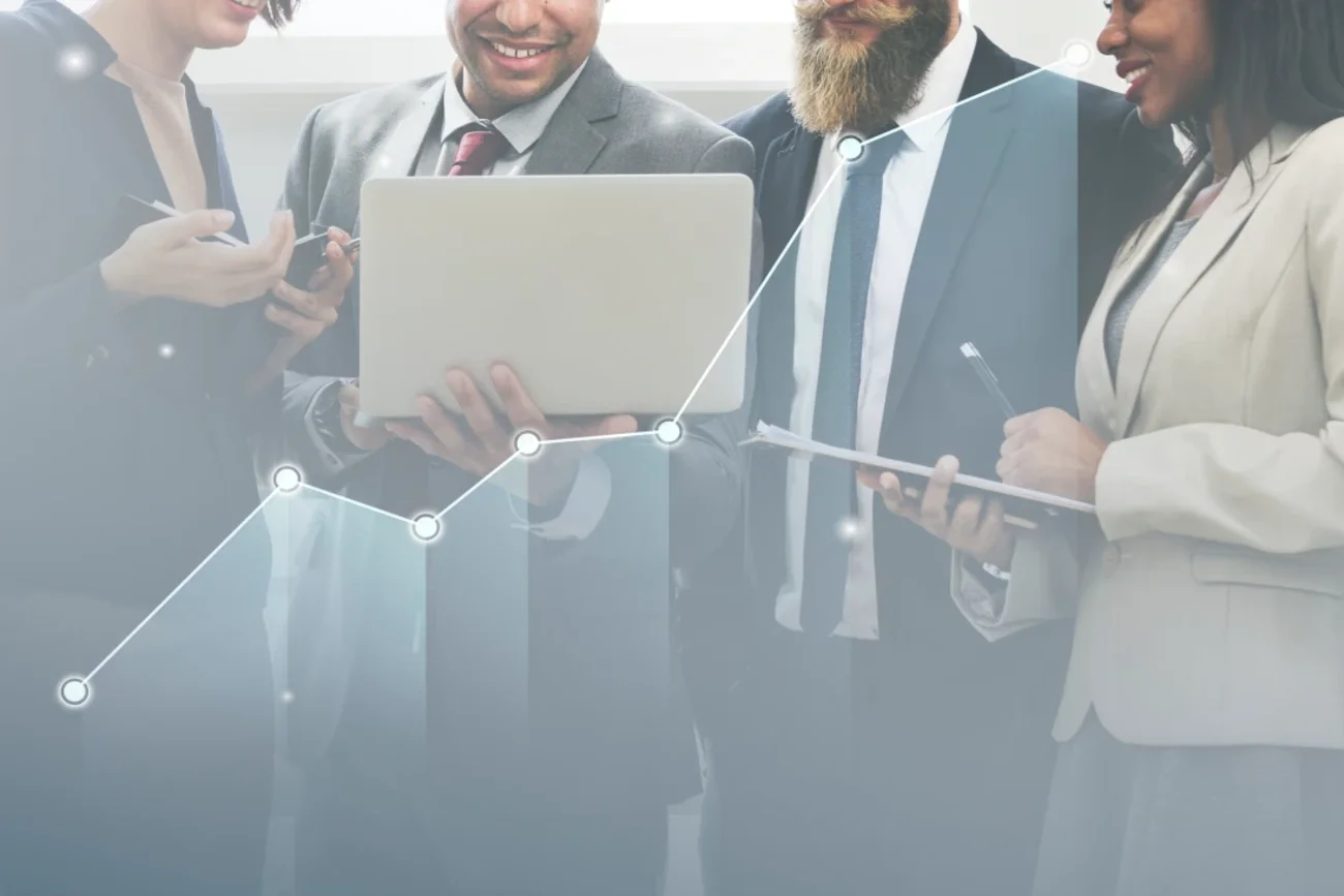Profissionais reunidos analisando dados de desempenho em um notebook, com gráfico de crescimento sobreposto.